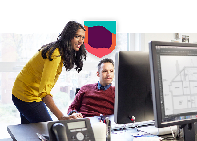 Man and woman collaborating on a computer.