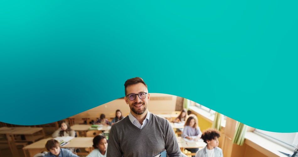 Man with glasses holding book in classroom.