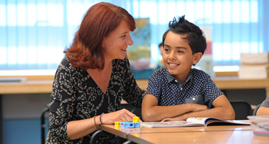 Woman and boy reading together at a table